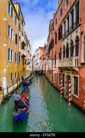 Venice, Italy. Image with tourists and gondola on small channel of Venice. Gondola is a traditional Venetian row