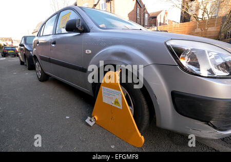 Manchester UK  04th February 2015 A car is clamped on Eversley Road, Didsbury, South Manchester for being untaxed, but a valid tax disc is in the window.  Unfortunately for the owner, it should be on the passenger side of the car. At the time of the offence tax disc are no longer issued.Taxed Car Clamped  Manchester, UK Credit:  John Fryer/Alamy Live News Stock Photo