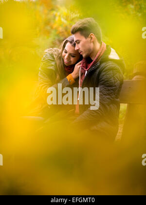 Loving couple in the autumn park sitting on a bench