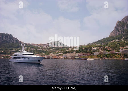 Yacht anchored at the coast of Capri, Italy. In the background Marina  Piccola Stock Photo