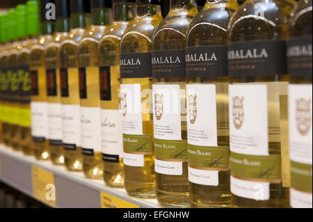 Bottles of white wine and alcohol on a shelf in a UK budget supermarket. Stock Photo