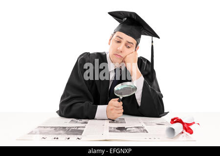 Graduate student searching for job in the papers isolated on white background Stock Photo