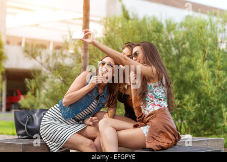 Three beautiful woman eating ice cream during selfie doing photo Stock Photo