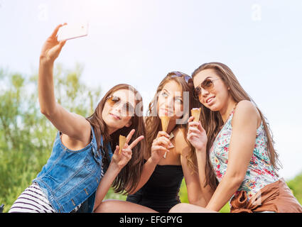 Three beautiful woman eating ice cream during selfie doing photo Stock Photo
