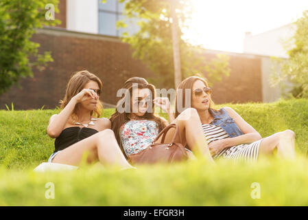 Three Beautiful woman looking at the handsome men in the grass Stock Photo