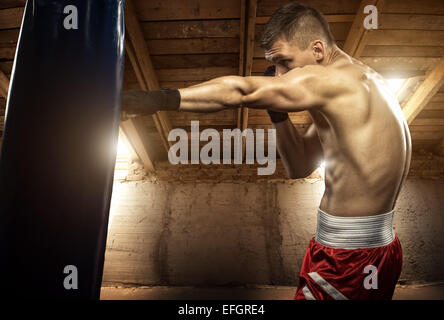 Young man boxing, exercise in the attic Stock Photo