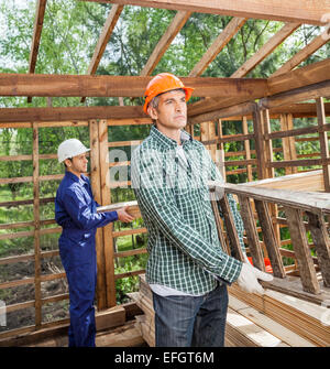 Construction Workers Working In Timber Cabin At Site Stock Photo