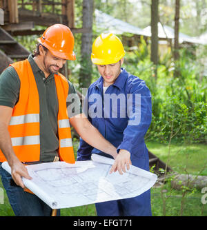 Architects Discussing Over Blueprint Stock Photo
