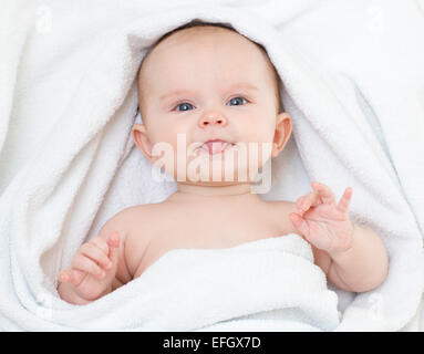 Cute funny baby in bathing towel showing tongue