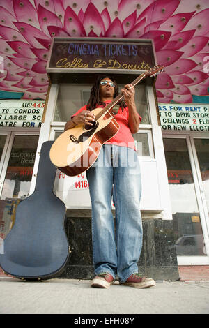 Street busker playing guitar Stock Photo