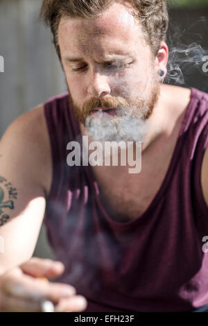 Close up of man who smokes on the staircase Stock Photo
