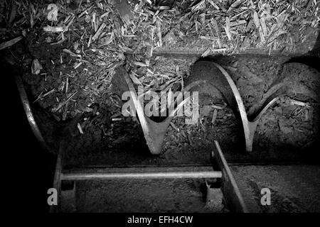 Detail of spiral industrial machine component in biomass plant, black & white close up Stock Photo