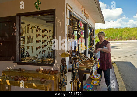 Horizontal portrait of a female tourist buying souvenirs at a roadside shop in Cuba. Stock Photo