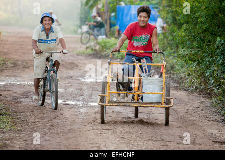 Early to Work: tools and a dog. Construction Workers set off by bicycles to their worksites, tools and dog in basket Stock Photo
