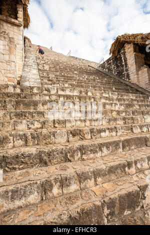 A tourist climbs the stairs to the Acropolis at Ek' Balam. This long set of stairs leads up to the temple and Tomb Stock Photo