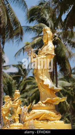 beautiful statue Guan Yin Chinese Goddess of Mercy in the palm grove Stock Photo