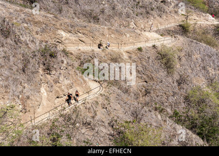 The Long Dry Walk to the Top. Hikers trek up and down the narrow winding path to the summit of Diamond Head Stock Photo