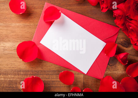 Bouquet of roses with blank paper with envelope on wooden desk Stock Photo