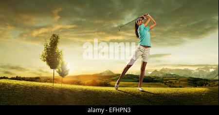 Woman golfer hitting the ball on the background scenery  beautiful Stock Photo