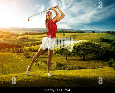 Woman golfer hitting the ball on the background scenery  beautiful Stock Photo