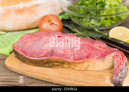 raw steak catfish on a cutting Board