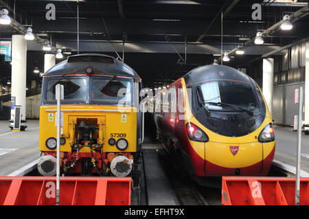 Class 57 diesel locomotive and class 390 electric multiple unit (Pendolino) train in London Euston railway station. Stock Photo