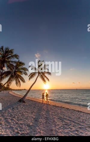 Morning impression with couple jogging along the beach at sunrise, Key West Smathers Beach, Key West, Florida Keys, Florida, USA Stock Photo
