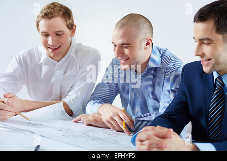 Three male architects discussing sketch at meeting Stock Photo
