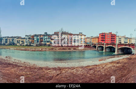 Parma, Italy - March 02, 2013: Parma river with typical city houses and bridge in winter day. Parma River is a large stream of 9 Stock Photo