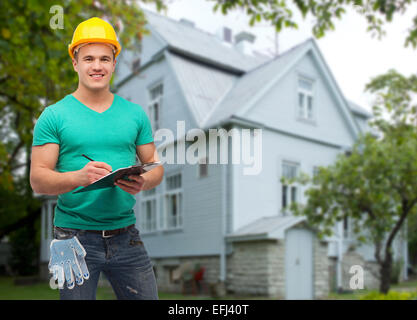 smiling manual worker in helmet with clipboard Stock Photo