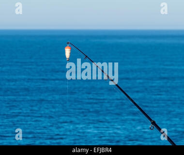 Fishing Bait-Rod with Float against the Blue Sea Water Surface, closeup Stock Photo