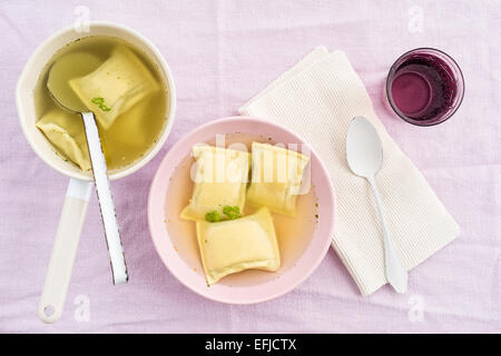 Maultaschen filled pasta squares in broth with water Stock Photo