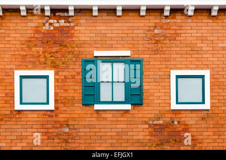 Green window on the orange brick wall outside the house in the Italy retro style Stock Photo