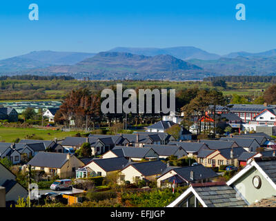 View over the town of Harlech in Gwynedd North Wales UK towards distant mountains on the Llyn Peninsula with clear blue sky Stock Photo