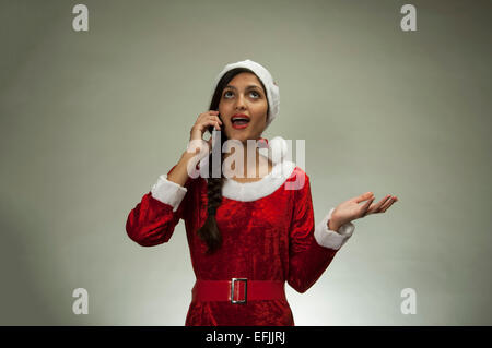 Woman with Santa hat holding a mobile phone Stock Photo