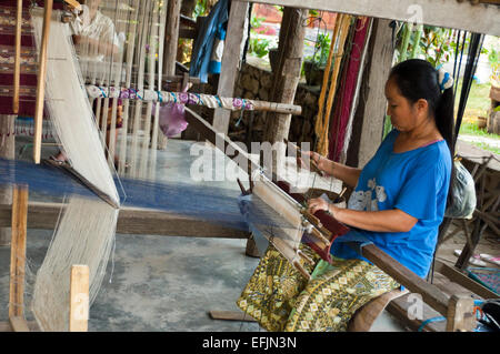 Horizontal portrait of a Lao lady at her loom in a silk factory in Laos. Stock Photo