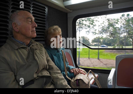 Jan 2014. Horizontal portrait of two elderly passengers sitting together on the back of a bus. Stock Photo
