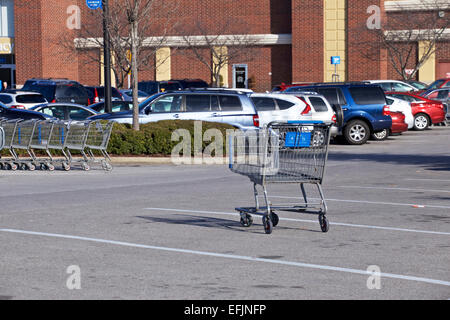 Single shopping cart in walmart parking lot. Stock Photo