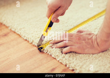 close up of male hands cutting carpet Stock Photo