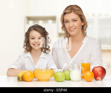 happy mother and daughter eating breakfast Stock Photo