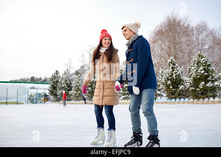 happy couple ice skating on rink outdoors Stock Photo