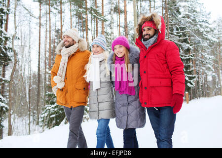 group of smiling men and women in winter forest Stock Photo