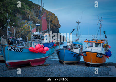 Beached fishing boats at evening low tide in Cadgwith Cove, Cornwall, England, UK Stock Photo