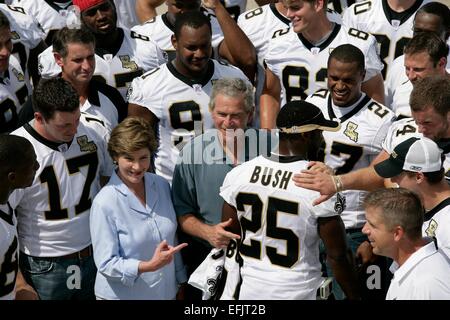 US President George W. Bush and First Lady Laura Bush are surrounded by members of the New Orleans Saints football team points out the name of Saints star rookie running back Reggie Bush August 29, 2006 in New Orleans, Louisiana. Stock Photo