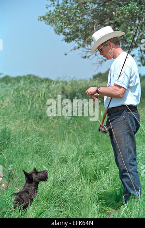 US President George W. Bush wearing a cowboy hat with his dog Barney as he goes fishing at the Ranch April 28, 2002 in Crawford, Texas. Stock Photo