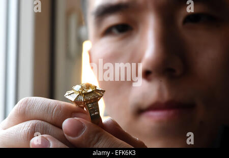 Beijing, China. 6th Feb, 2015. Stylist Wang Xu introduces a ring he designed during a free jewellery exhibition that combines the Chinese and western cultures in Beijing, capital of China, Feb. 6, 2015. Displaying jewellery that are made with western craftwork and embody traditional Chinese style, the exhibition will last until Feb. 12. Credit:  Jin Liangkuai/Xinhua/Alamy Live News Stock Photo