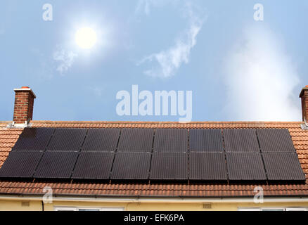 The Sun shining down on a house roof which has 16 solar panels mounted on it. Stock Photo