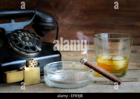 Cigar and whiskey abstract retro still life with telephone on table Stock Photo
