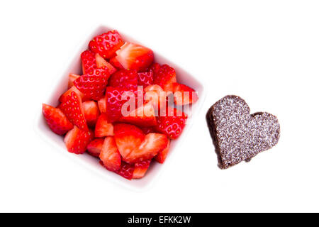 Sweet heart-shaped and strawberries on white background seen from above Stock Photo