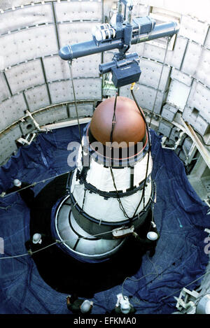 Members of the Air Force 390th Missile Maintenance Squadron guide a Titan II reentry vehicle warhead as it is lifted out of a May 22, 1984 in Davis Monthan Air Force Base in Tucson, Arizona. Stock Photo